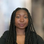 Myeisa Barnhill Young woman with braids. Wearing a black shirt.