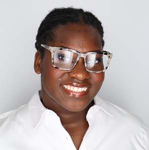 African American young woman with glasses with short hair and glasses and wide simile. She is wearing a white shirt
